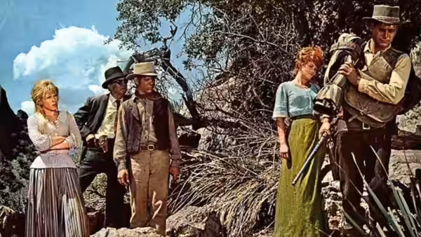 John Russell (Paul Newman) stands with armed travelers beside a wagon outdoors