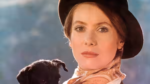 Tristana (Catherine Deneuve) wears a broad-brimmed hat beside a black dog