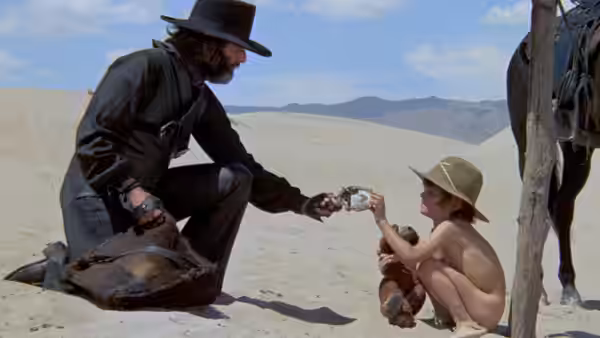 El Topo (Alejandro Jodorowsky) gives his young son a revolver in the desert