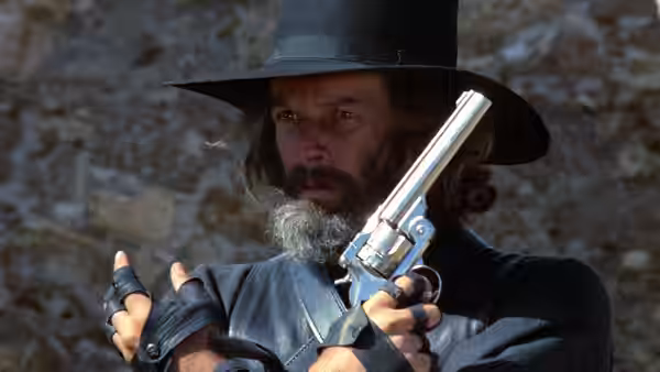 El Topo (Alejandro Jodorowsky) holds a revolver before a stone wall