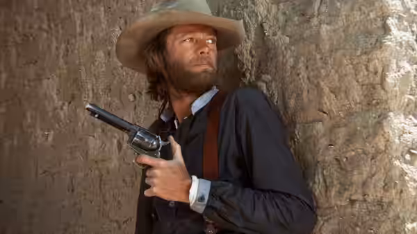 Harry Collings (Peter Fonda) holds a revolver against a rough adobe wall
