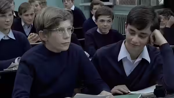 Schoolboys sit at their desks in a classroom