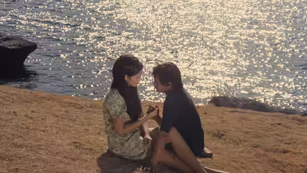Ligaya Paraiso (Hilda Koronel) and Julio Madiaga (Bembol Roco) sit close together beside the water