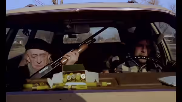 Scheitz (Clemens Scheitz) holds a shotgun beside Bruno Stroszek (Bruno Schleinstein) in a car