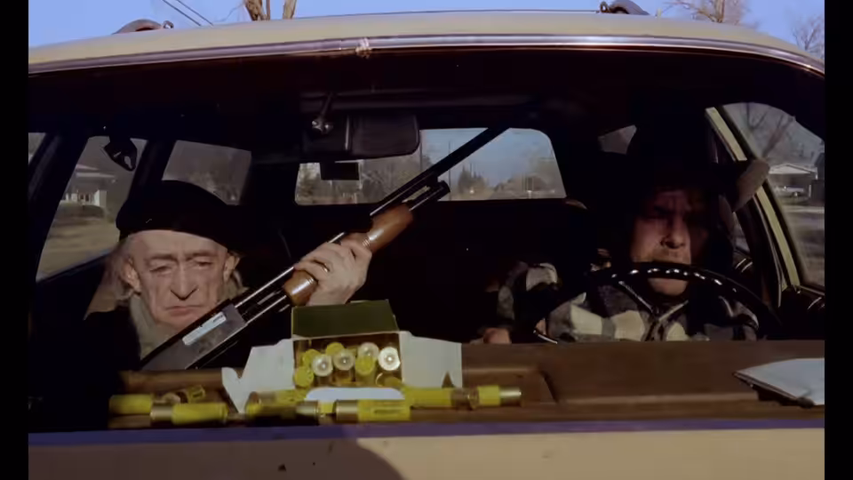 Scheitz (Clemens Scheitz) holds a shotgun beside Bruno Stroszek (Bruno Schleinstein) in a car
