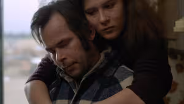Bruno Stroszek (Bruno Schleinstein) sits with Eva (Eva Mattes) embracing him from behind