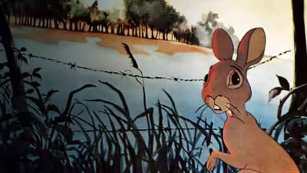 A rabbit peers through grass near barbed wire with a bird perched on it
