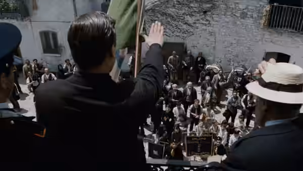 Carlo Levi (Gian Maria Volonté) waves to a crowd gathered in a village square