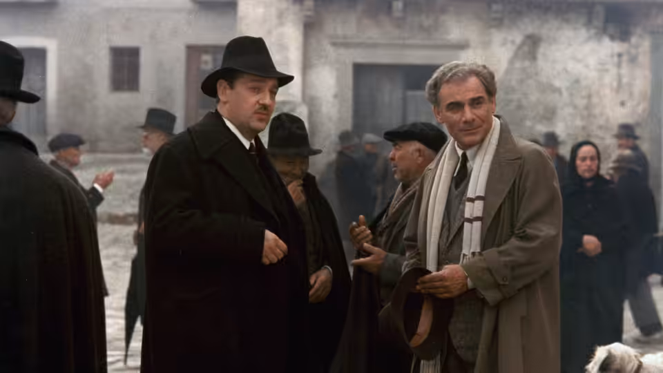 Carlo Levi (Gian Maria Volonté) stands among villagers in a stone village square