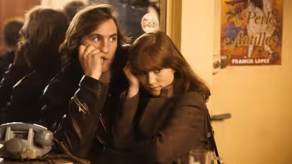 Loulou (Gérard Depardieu) and Nelly (Isabelle Huppert) sit close together at a counter