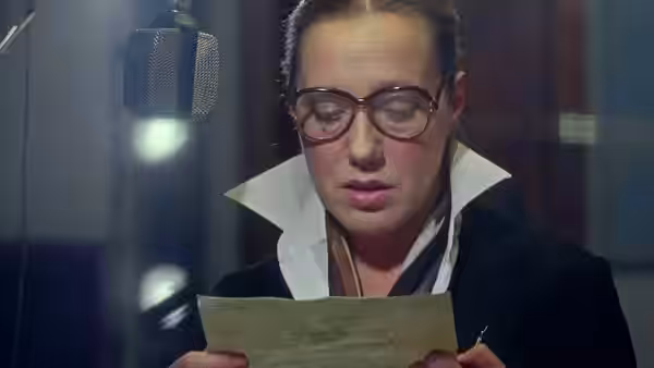 Agnieszka (Krystyna Janda) reads from a paper beside a studio microphone