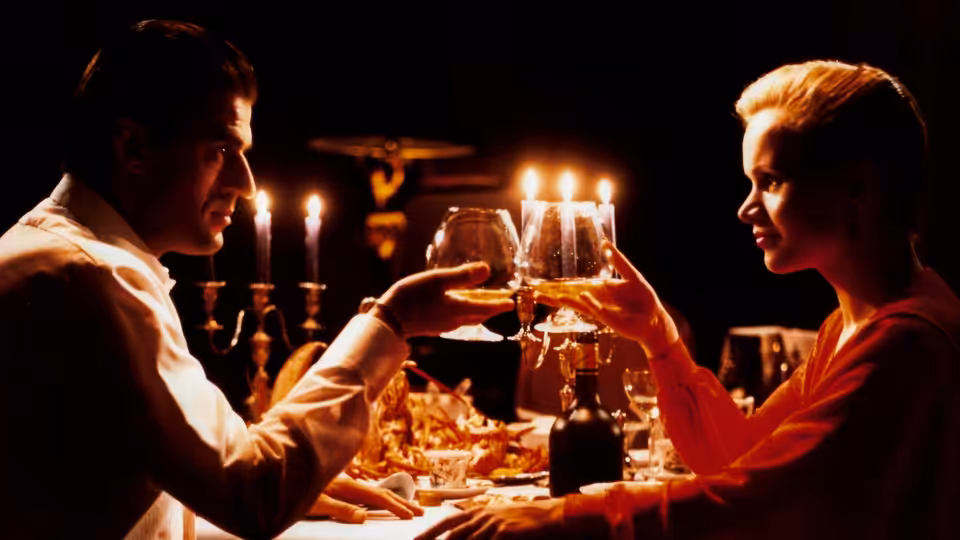 Gerard Reve (Jeroen Krabbé) and Christine Halslag (Renée Soutendijk) raise wine glasses across a candlelit dinner table