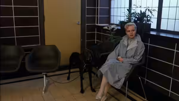 Christine Halslag (Renée Soutendijk) sits in a waiting room beside a black dog