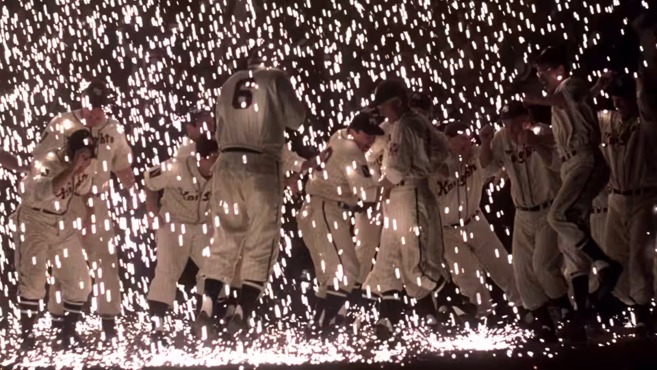 Baseball players gather beneath a shower of fireworks on the field