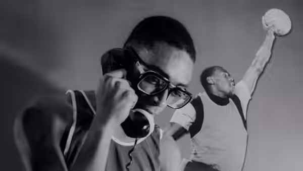 Mars Blackmon (Spike Lee) talks on the phone beneath a basketball player raising a ball