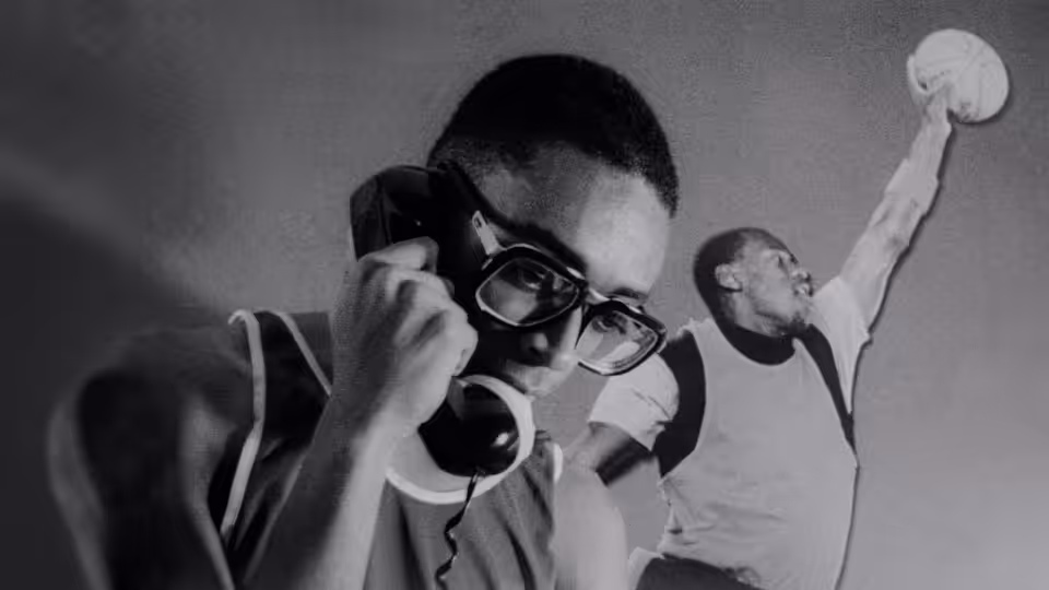 Mars Blackmon (Spike Lee) talks on the phone beneath a basketball player raising a ball