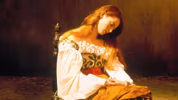 Lena (Tilda Swinton) sits in a chair, head bowed over her hands