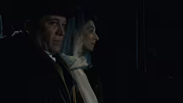 Gabriel and Gretta Conroy sit side by side in a dark carriage