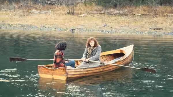 Sylvie Fisher (Christine Lahti) and Ruth (Sara Walker) sit together in a wooden rowboat