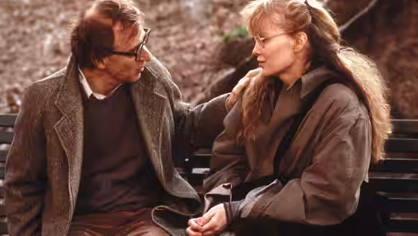 Cliff Stern (Woody Allen) rests a hand on Halley Reed’s (Mia Farrow) shoulder on a park bench