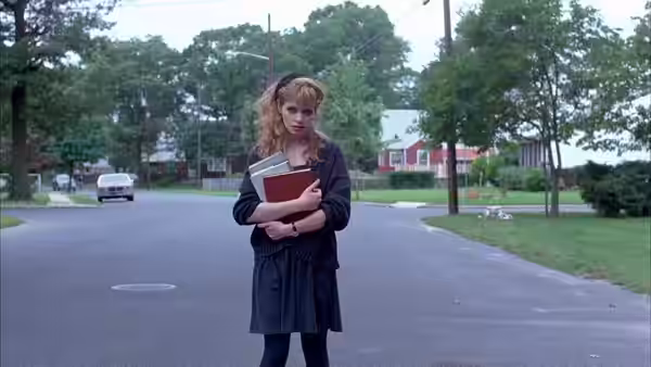 Audry (Adrienne Shelly) stands in the road, clutching books to her chest