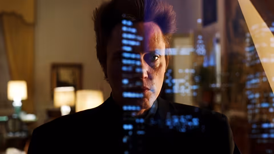 Frank White (Christopher Walken) looks through glass reflecting city lights inside a room