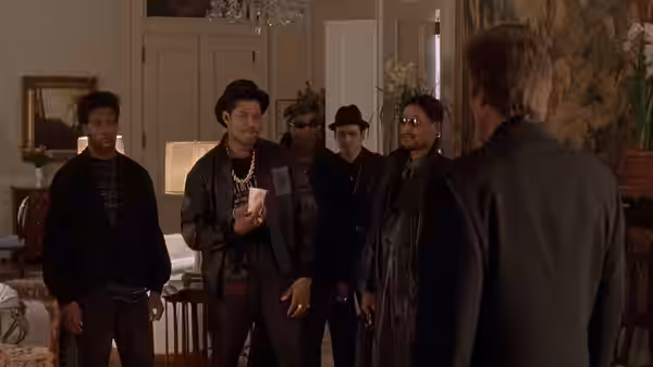 A group of men faces Frank White (Christopher Walken) in a furnished apartment