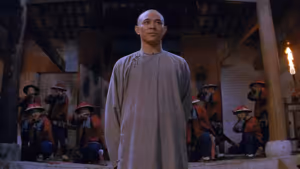 Wong Fei Hung (Jet Li) stands before seated guards in a courtyard