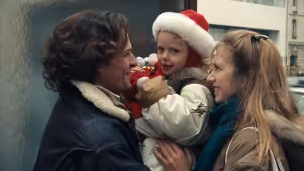 Charles and Félicie hold their young daughter between them on a city street