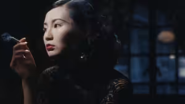 Ruan Lingyu (Maggie Cheung) holds a cigarette by a dark window