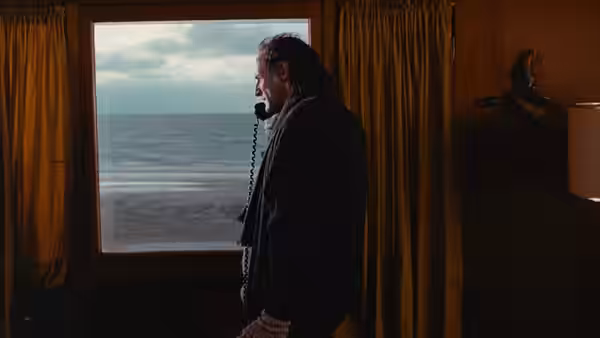Glenn Gould (Colm Feore) stands by a window, speaking on the telephone as the sea stretches beyond