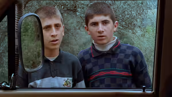 Two young men look through a vehicle window