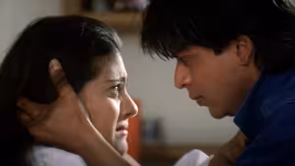Raj Malhotra (Shah Rukh Khan) holds Simran Singh's (Kajol) face as she cries