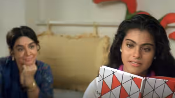 Simran Singh (Kajol) reads a geometric-patterned book while Lajjo Singh watches behind her