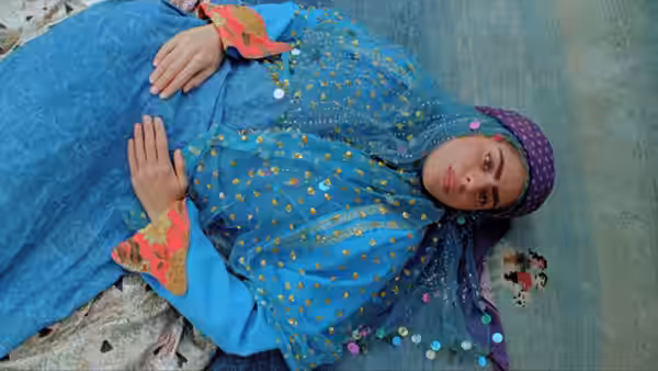 Gabbeh (Shaghayeh Djodat) lies on a carpet with her hands resting on her belly