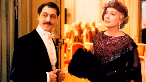 Marcel (Marcello Mazzarella) and Odette (Catherine Deneuve) pause in an ornate interior