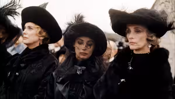 Three women in elaborate black hats and mourning clothes stand together