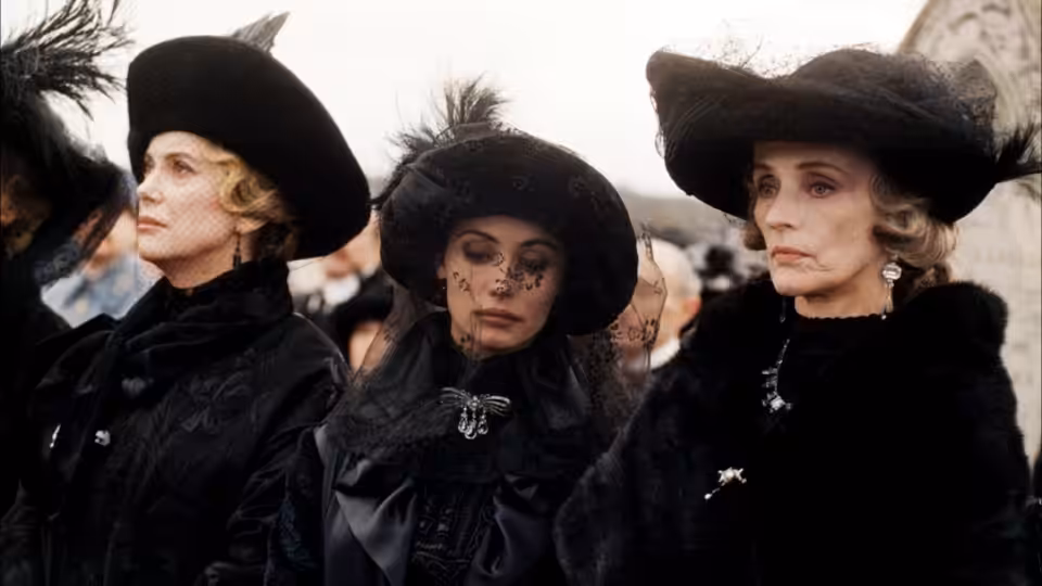 Three women in elaborate black hats and mourning clothes stand together