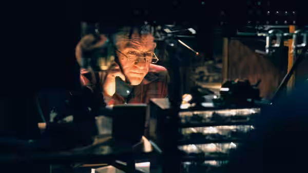 Jack watches from behind the polygraph equipment in his basement