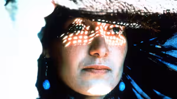 Nafas (Nelofer Pazira) looks out from beneath a perforated veil, sunlight dappling her face