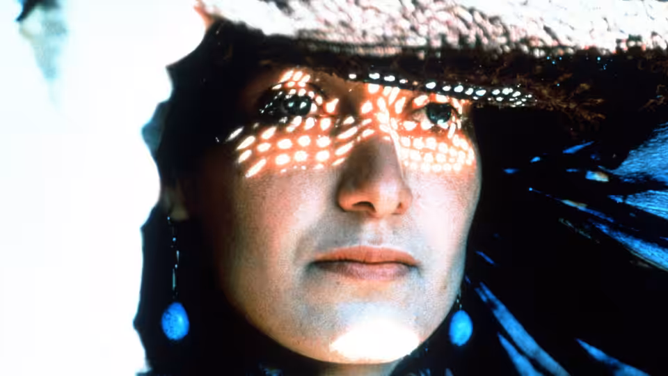 Nafas (Nelofer Pazira) looks out from beneath a perforated veil, sunlight dappling her face