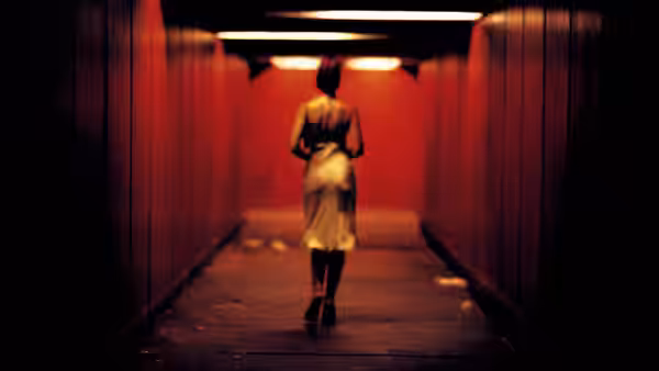 Alex (Monica Bellucci) walks through a red-lit underground passage
