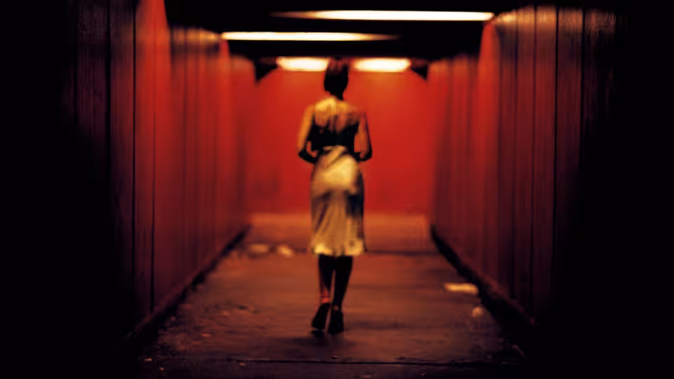 Alex (Monica Bellucci) walks through a red-lit underground passage