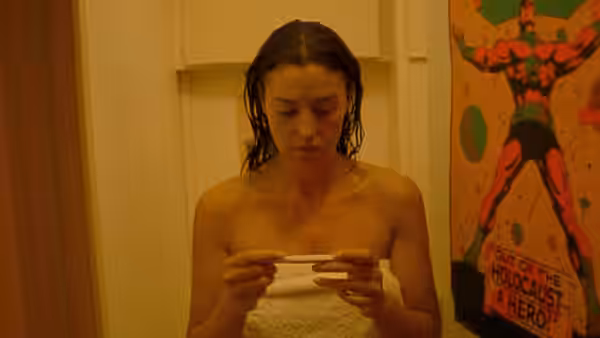 Alex (Monica Bellucci) studies a pregnancy test in a bathroom
