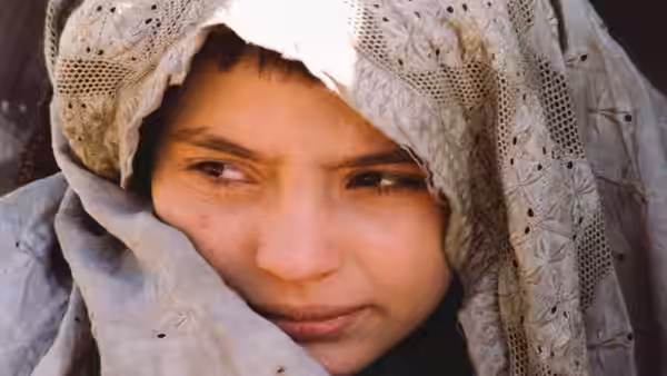 Osama (Marina Golbahari) peers from beneath a pale embroidered headscarf