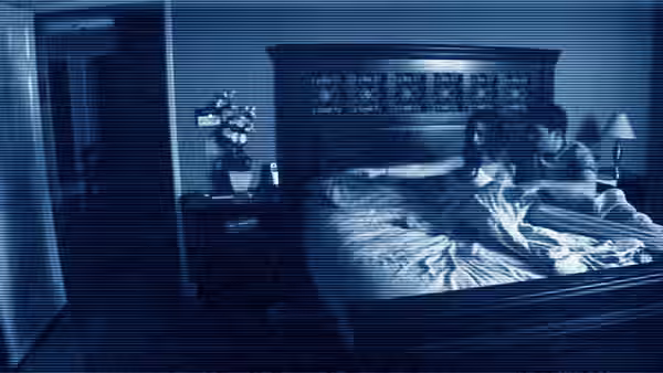 Katie (Katie Featherston) and Micah (Micah Sloat) sit up together in bed