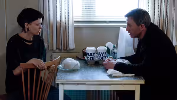 Lisbeth Salander (Rooney Mara) and Mikael Blomkvist (Daniel Craig) talk across a small table