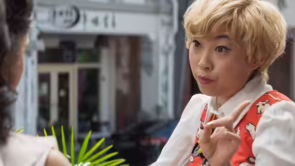 Peik Lin (Awkwafina) gestures while talking with Rachel outside