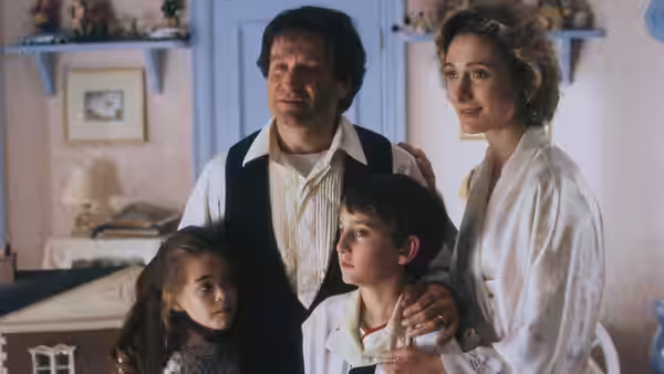 Peter Banning (Robin Williams) stands with his wife and two children in a bedroom