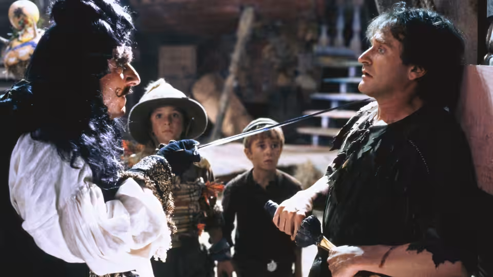 Captain Hook (Dustin Hoffman) confronts Peter Banning (Robin Williams) with sword drawn as two boys watch